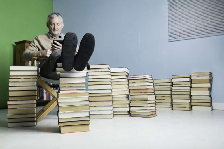 2 TFSA Investing Tactics Used by Wealthy Canadians a man relaxes with his feet on a pile of books