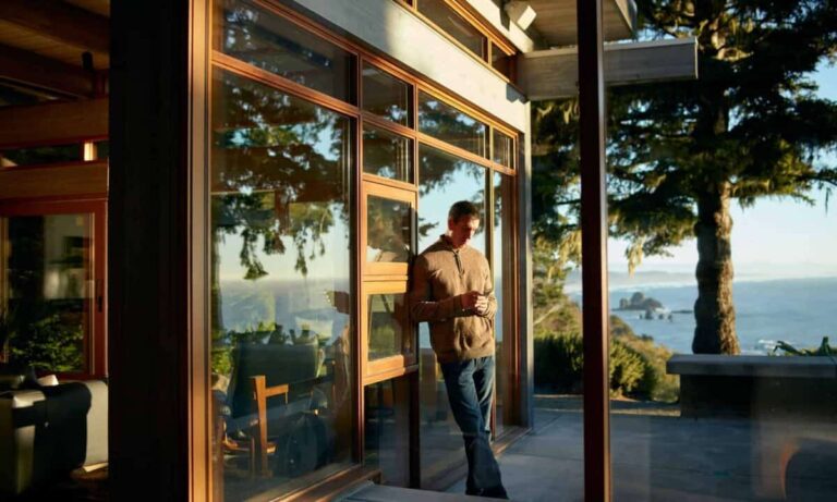 Is BCE Still a Buy? Here’s My Verdict person on phone leaning against outside wall with scenic view at airbnb rental property