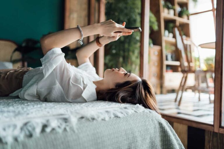 Telus Dividend Reliability: Is the Telecom Still Worth Holding? woman relaxes with phone